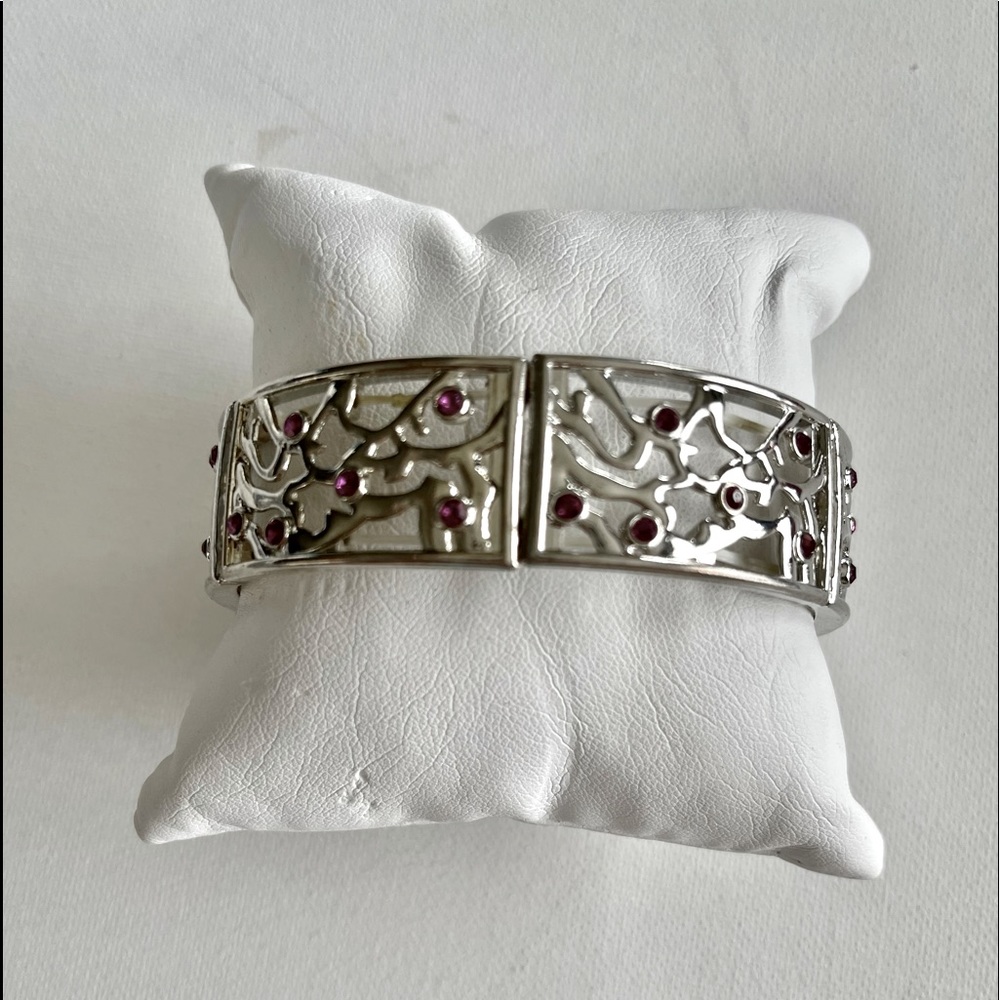 Very pretty sliver tone with dark pink jewels inlaid throughout. One size